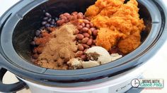 a crock pot filled with beans, spices and mashed potatoes for the meal