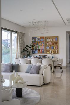 a living room filled with furniture and a chandelier hanging from the ceiling next to a large window