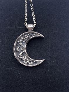 "A crescent shaped moon with a solid bail. Inside the moon is a floral scrollwork pattern. We cast this is solid sterling silver, with a dark patina to really make it pop! Pendant including bail is 26mm high and 20mm wide. This item is custom made to order. That means it may take an extra second or two to make your entire piece by hand. We try to beat shipping estimates, but its just a one woman team in this shop! Our supplier of casting grain uses SCS-certified 100% recycled metal. We make ever Moon Pendant Necklace Silver, Elegant Crescent Jewelry With Oxidized Finish, Elegant Crescent Oxidized Jewelry, Silver Crescent Jewelry With Oxidized Finish, Silver Oxidized Moon Shaped Jewelry, Silver Crescent Filigree Jewelry, Vintage Moon Shaped Sterling Silver Jewelry, Vintage Sterling Silver Moon Jewelry, Vintage Moon-shaped Sterling Silver Jewelry