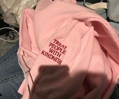 a pink shirt with the words treat people with knives on it sitting in someone's lap