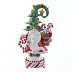 a christmas ornament with a santa clause holding a basket and candy canes