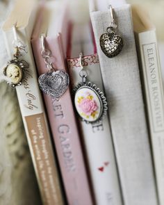 some books are stacked on top of each other and have heart charms attached to them