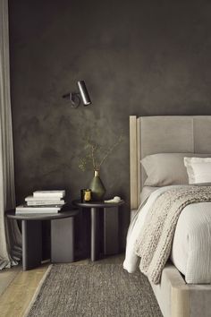 a bedroom with gray walls and white bedding