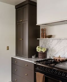 a stove top oven sitting inside of a kitchen next to a wall mounted oven hood