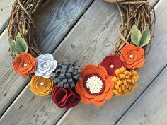 a wreath made out of paper flowers on top of a wooden floor