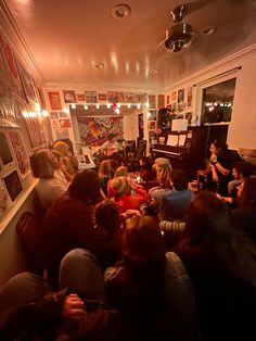 a group of people sitting around in a room with pictures on the wall and paintings on the walls