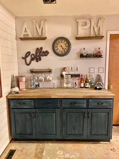 a kitchen with blue cabinets and an old clock mounted on the wall above it's counter