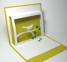 an open card with a bird sitting on a tree branch in the middle of it