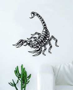 a scorpion wall decal on a white wall next to a potted green plant