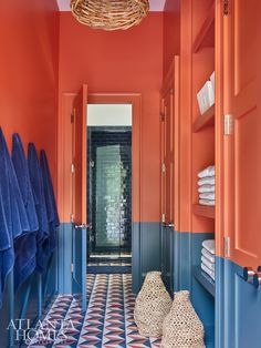 an orange and blue bathroom with towels hanging on the rack in front of the door