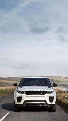 a white range rover driving down the road