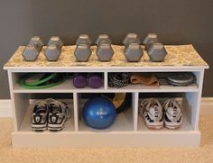 a white shelf filled with lots of shoes and dumbbells on top of it