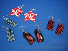 coca cola earrings and earring set on blue background