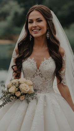 a woman in a wedding dress holding a bridal bouquet and smiling at the camera