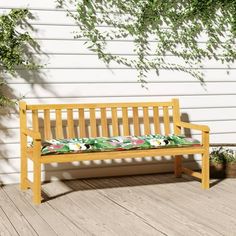 a wooden bench sitting on top of a wooden deck next to a plant filled wall