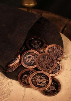 a pile of coins sitting on top of a stone slab next to a black hat