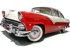 an old red and white car is parked on the floor in front of a white background