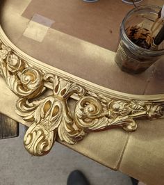 an ornate gold table with a glass on top