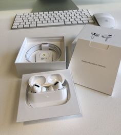 an apple airpods sitting in a box next to a keyboard and mouse on a table