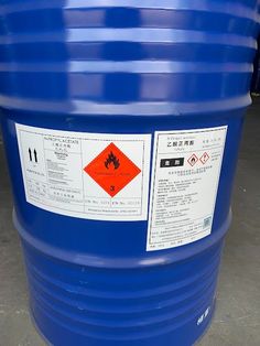 a large blue barrel sitting on top of a cement floor next to a sign that says,