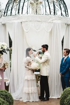 a bride and groom are getting married under a gazebo