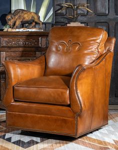 a brown leather chair sitting in front of a dresser