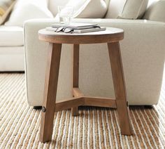 a white couch sitting next to a wooden table on top of a carpeted floor