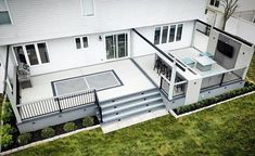 an aerial view of a house with decking and outdoor furniture in the backyard area