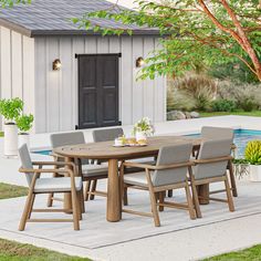 an outdoor table and chairs with a pool in the background