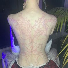 the back of a woman's body with pink lines on her upper and lower back