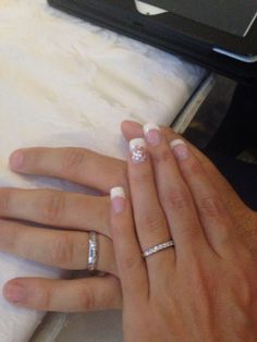 two people with wedding rings on their hands next to an open laptop computer and bed