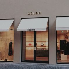 the store front of a clothing store with two mannequins in it's windows