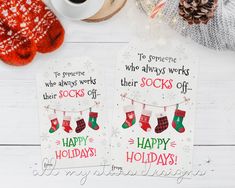 two christmas cards with stockings on them next to a cup of coffee and other items