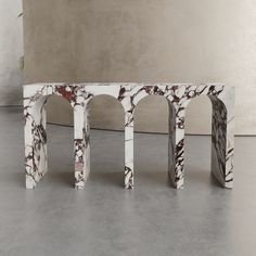 a marble bench sitting on top of a cement floor