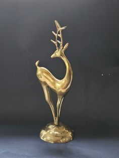 a brass statue of a deer with antlers on it's back