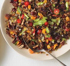 a bowl filled with rice and vegetables next to a plate full of other food items