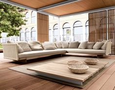 a large couch sitting on top of a wooden floor next to a table with two bowls