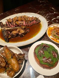 several plates with food on them sitting on a table