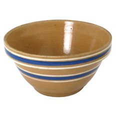 a brown bowl with blue and white stripes on the rim is sitting in front of a white background