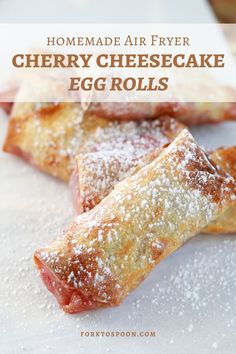 homemade air fryer cherry cheesecake egg rolls on a cutting board with powdered sugar