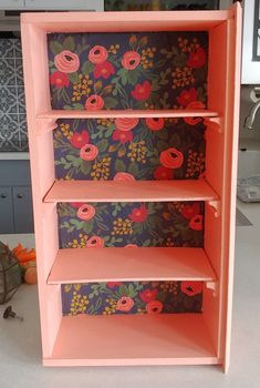 a pink shelf with flowers painted on it