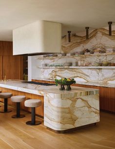 a kitchen with marble counter tops and stools