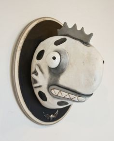 a wall mounted clock with a face on it