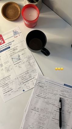 a table topped with papers and cups filled with liquid