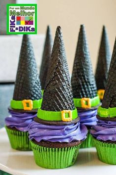 cupcakes decorated like witches with green and purple frosting on top, sitting on a plate