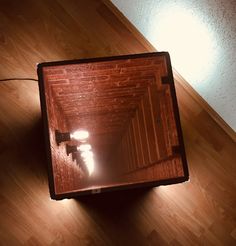 an overhead view of a room with wood flooring and light shining on the wall