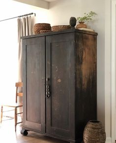 an old wooden cabinet with baskets on top