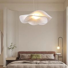 a bedroom with a large bed and two lights hanging from it's ceiling over the headboard