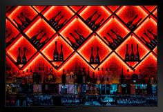 a bar with red lights and bottles on the shelves in front of it's back wall