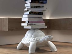 a white turtle is stacked with books on its back